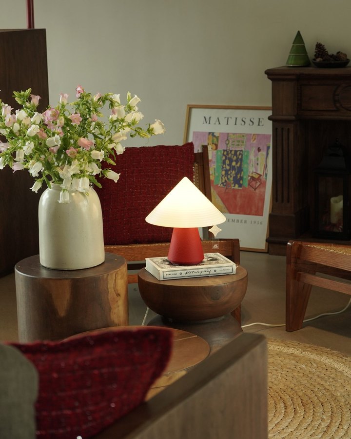 NOLA lamp glowing on a wooden side table in a warm living room